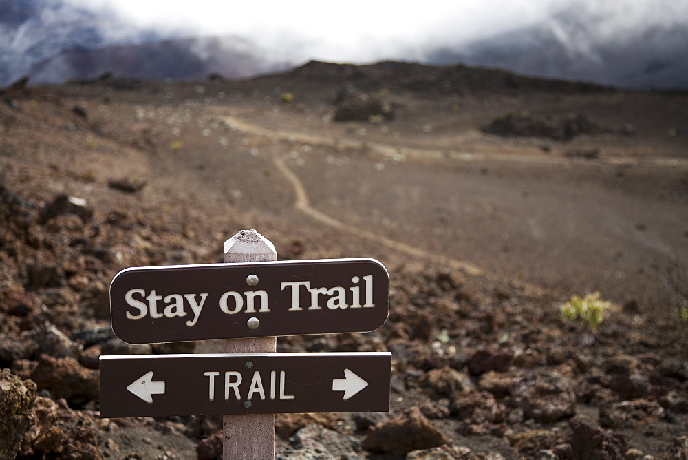 A sign telling hikers to stay on the trail in Haleakala crater. Hiking off-trail leads to significant soil erosion in the delicate volcanic soils, Maui, Hawaii, United States of America