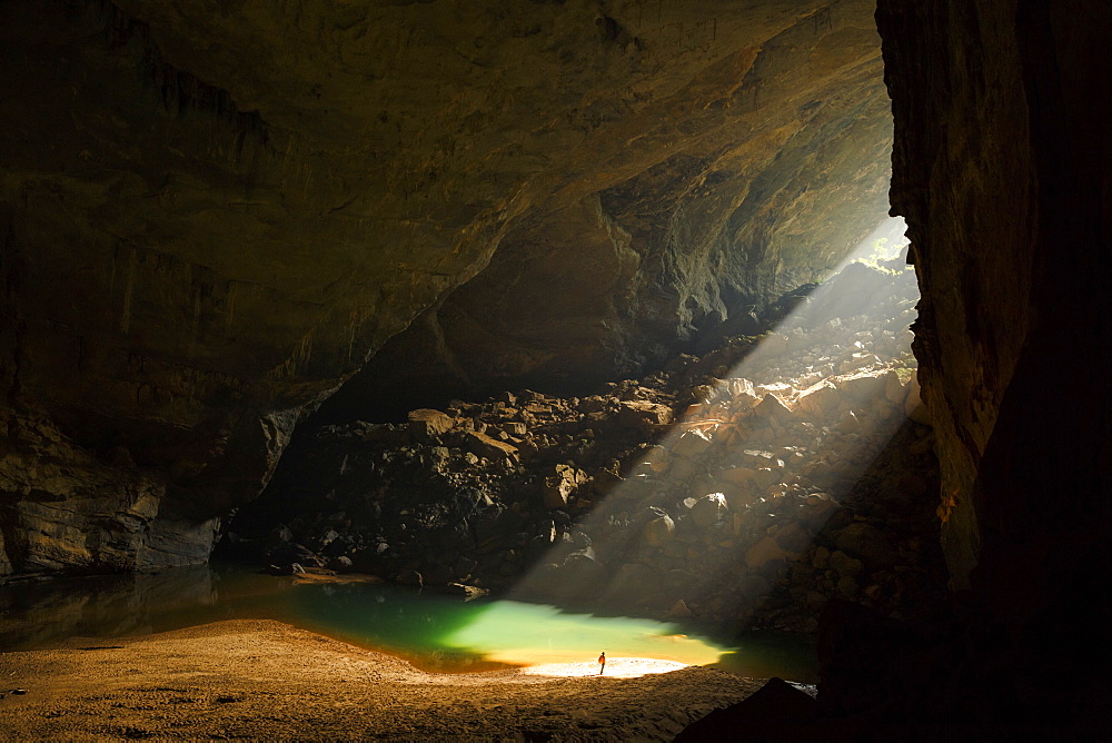 A caver stands in a sunbeam coming through an entrance to Hang En Cave in Phong Nha Ke Bang National Park, Vietnam. This natural phenomenon occurs only in the months of December and January.