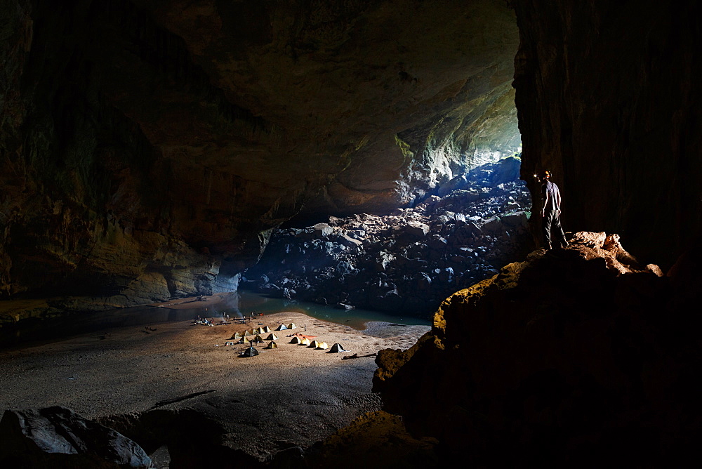 A cave explorer overlooks camp for the night from a high vantage point in Hang En, Phong Nha Ke Bang National Park, Vietnam.