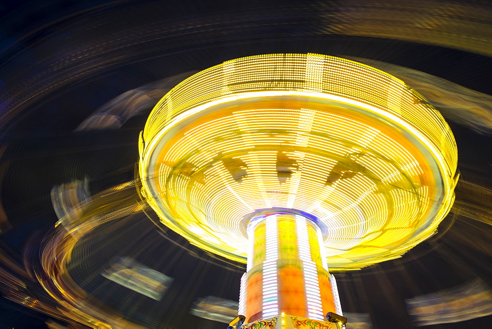 Long exposure of Chair Swing ride at Hamburger DOM funfair at night, St. Pauli, Hamburg, Germany