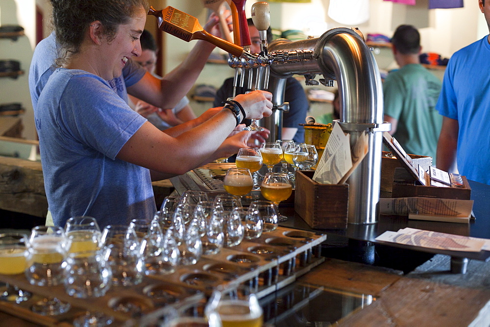 Bartender pours beers for tasting at Allagash Brewery