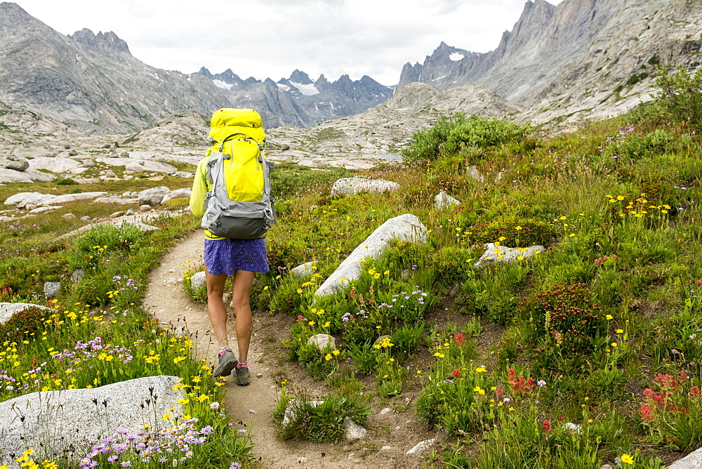 A woman hiking along trail into Titcomb Basin in the Wind River Range, Bridger Teton National Forest,  Pinedale, Wyoming.