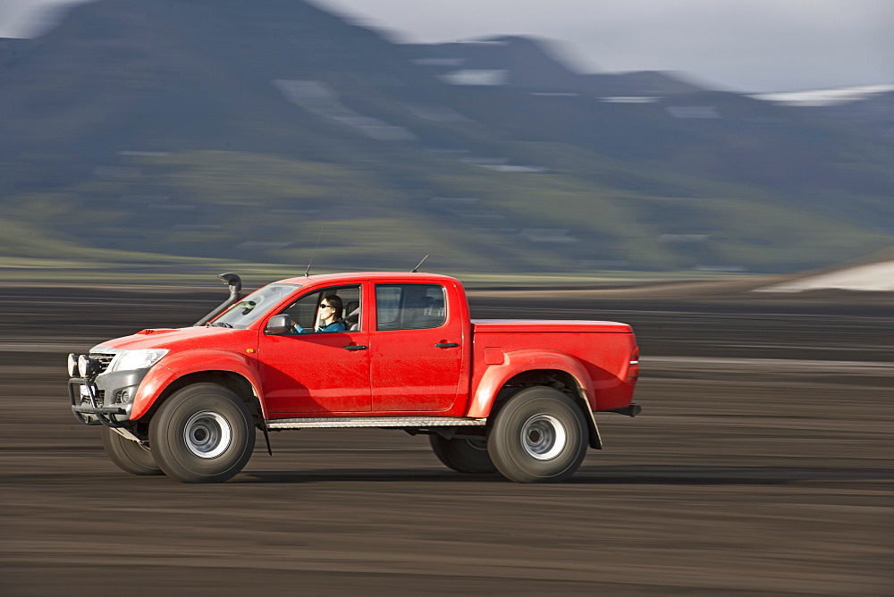 Woman driving customized pick up truck on Maelifellssandur area on the Icelandic highlands