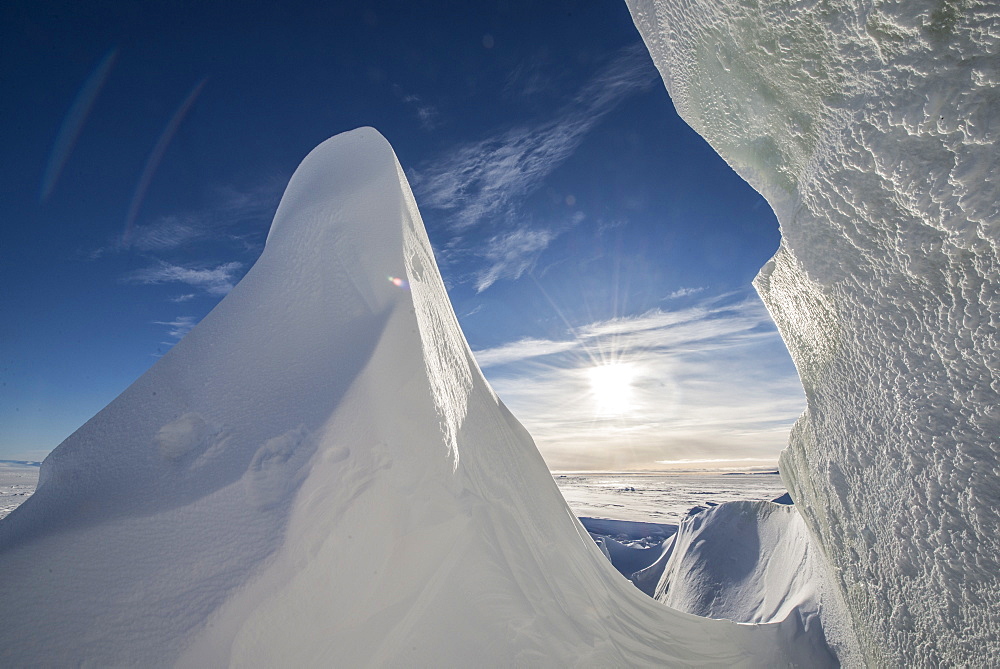 Sun shines through a crack in an iceberg in McMurdo Sound on the Ross Sea, Antarctica.