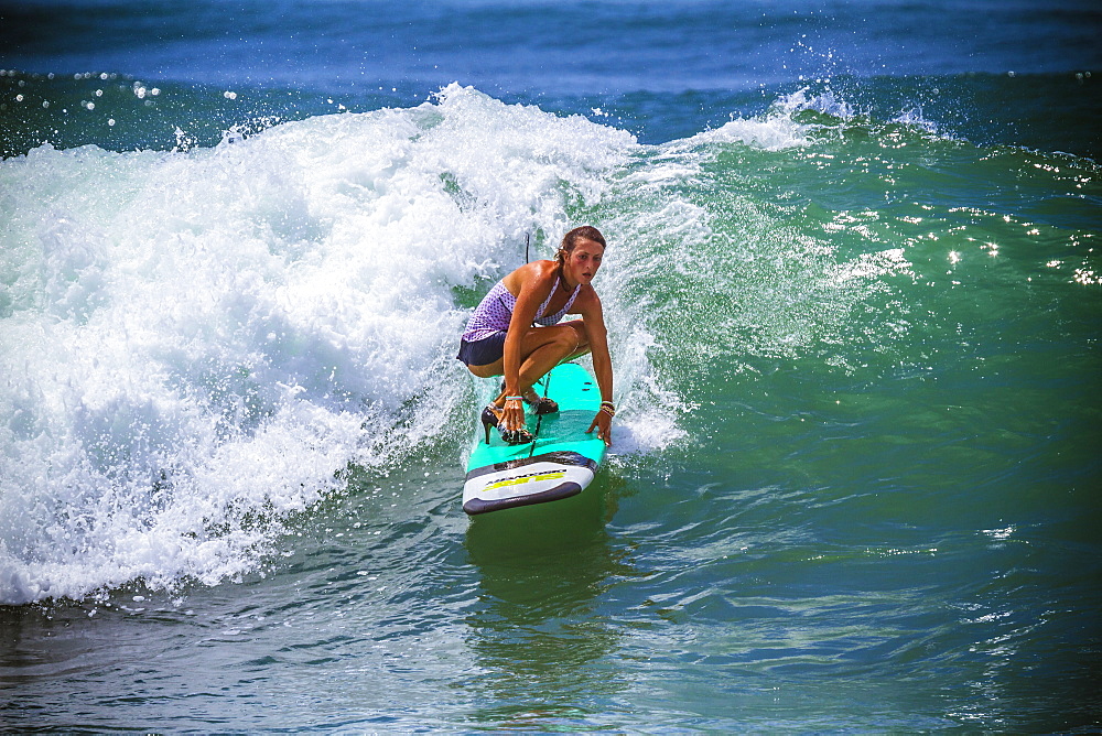 Surfer girl catches wave in high heels.