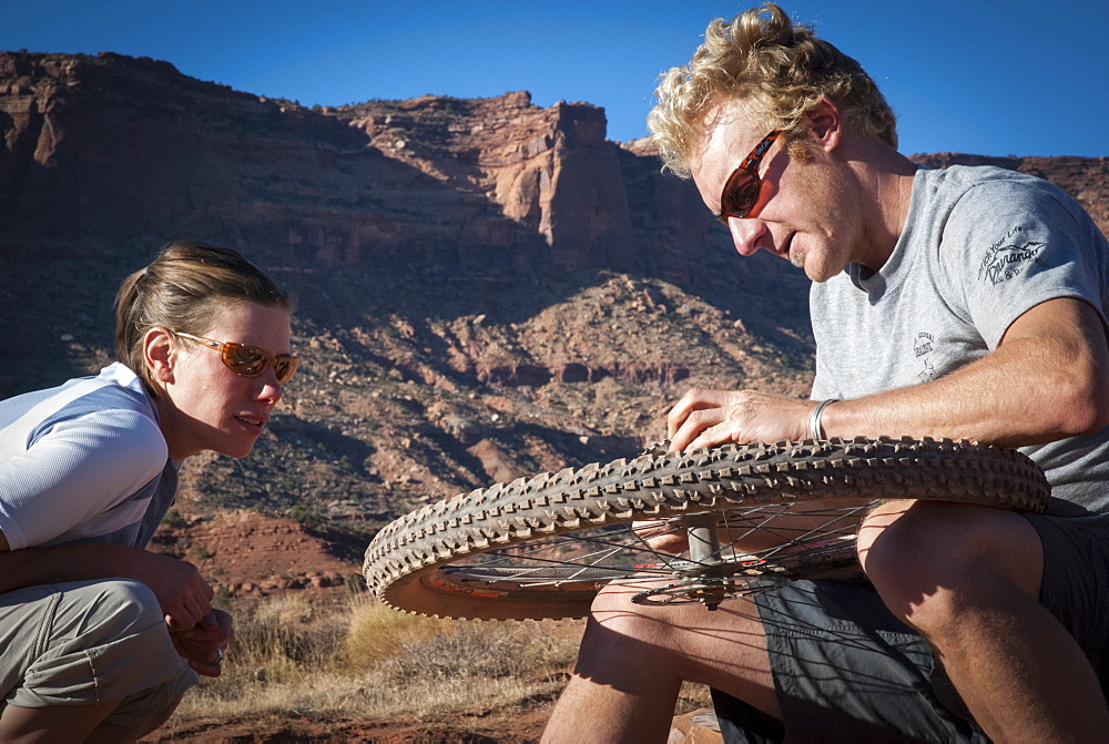 Friends explore the Utah desert in autumn with an extended mountain biking adventure on the White Rim Trail, Canyonlands National Park near Moab, Utah.