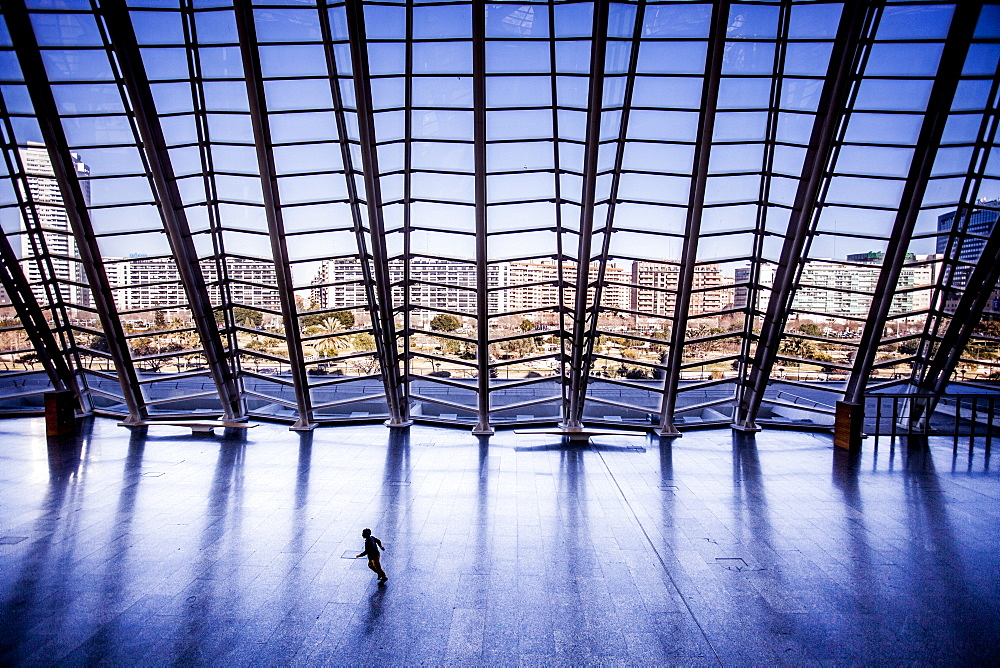 Child running across an empty floor at a museum.