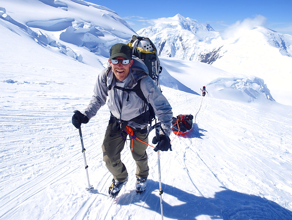 Mountain ranger Brian Scheele on this way to Windy Corner on Mount McKinley, also know as Denali, in Alaska. He is pulling a sled, that together with his heavy backpack is containing all the gear like tents, clothing and food.     Every climbing season High Mountain Rangers of the Denali National Park Service are called to help climbers in need. If possible the patient is brought down to Basecamp on foot, only in life threatening conditions a helicopter is called to evacuate the patient to a hospital in Anchorage.     Mount McKinley, native name Denali, is the highest mountain peak in North America, with a summit elevation of 20,321 feet (6,194 m) above sea level. At some 18,000 feet (5,500 m), the base-to-peak rise is considered the largest of any mountain situated entirely above sea level. Measured by topographic prominence, it is the third most prominent peak after Mount Everest and Aconcagua. Located in the Alaska Range in the interior of the U.S. state of Alaska, McKinley is the centerpiece of Denali National Park and Preserve.