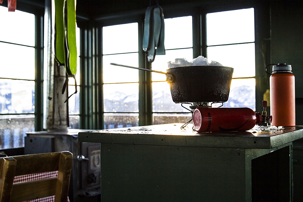 Melting snow on a camp stove in an old fire lookout in Montana.