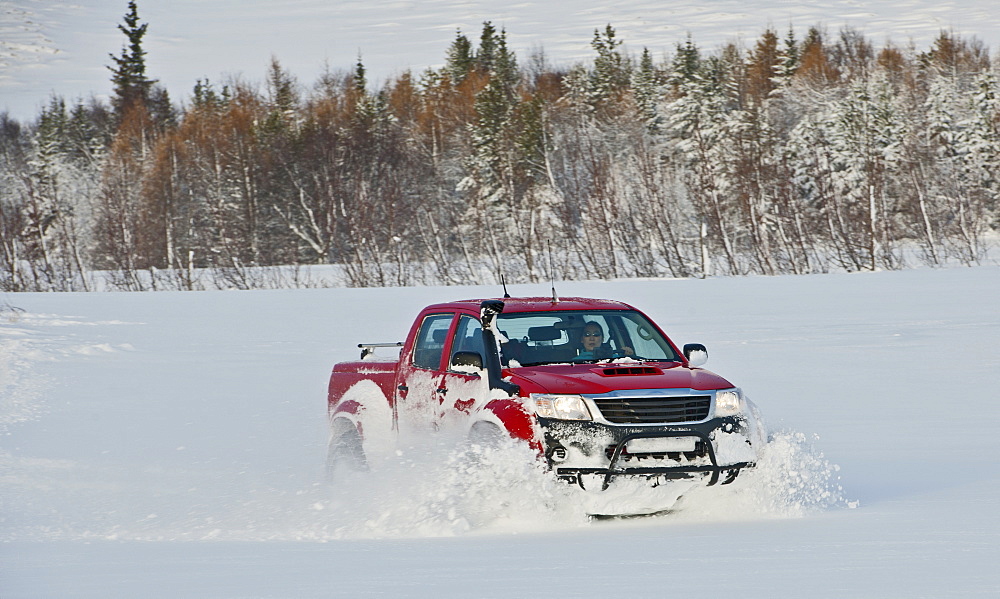 customised 4x4 pick up truck driving through deep snow close to Laugar in north Iceland