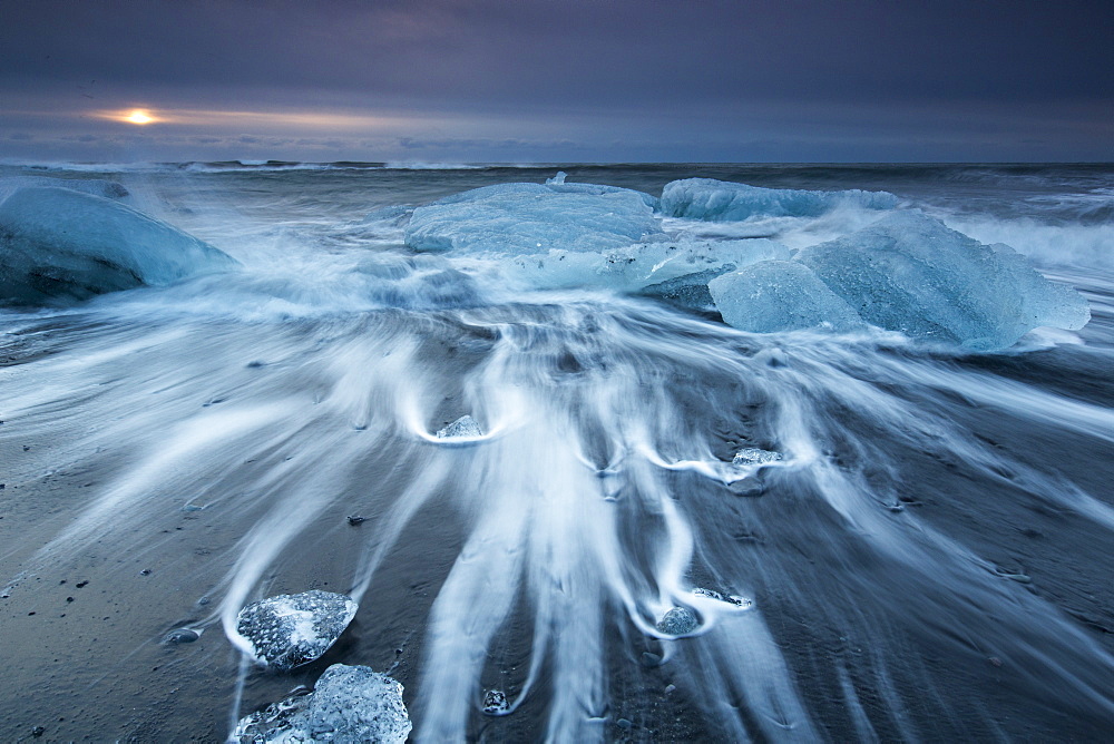 Glacial ice from Breiðamerkurjökull sits on the beach  of the coast at Breiðamerkursandur, Iceland, also known as the Jokulsarlon.