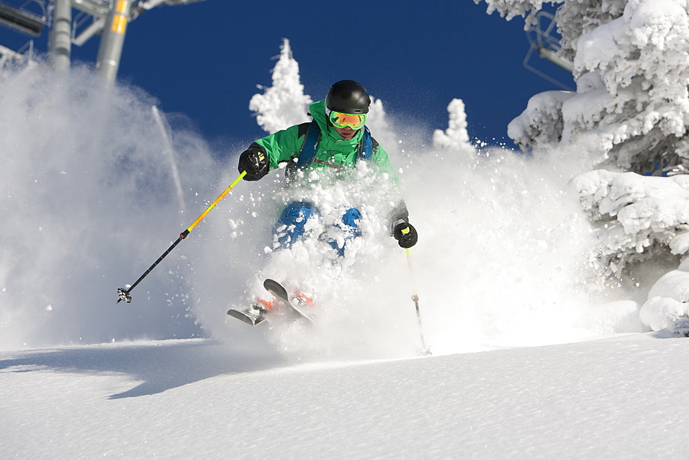 A man skiing powder on a beautiful sunny day in Utah.