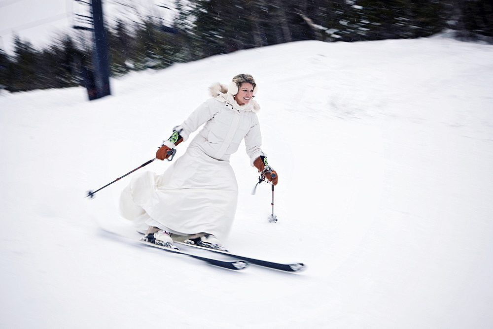 A woman skis down a mountain in a wedding dress after getting married.