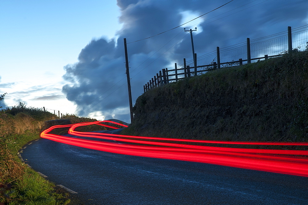 Car streaks on the narrow hillside roads of Dingle