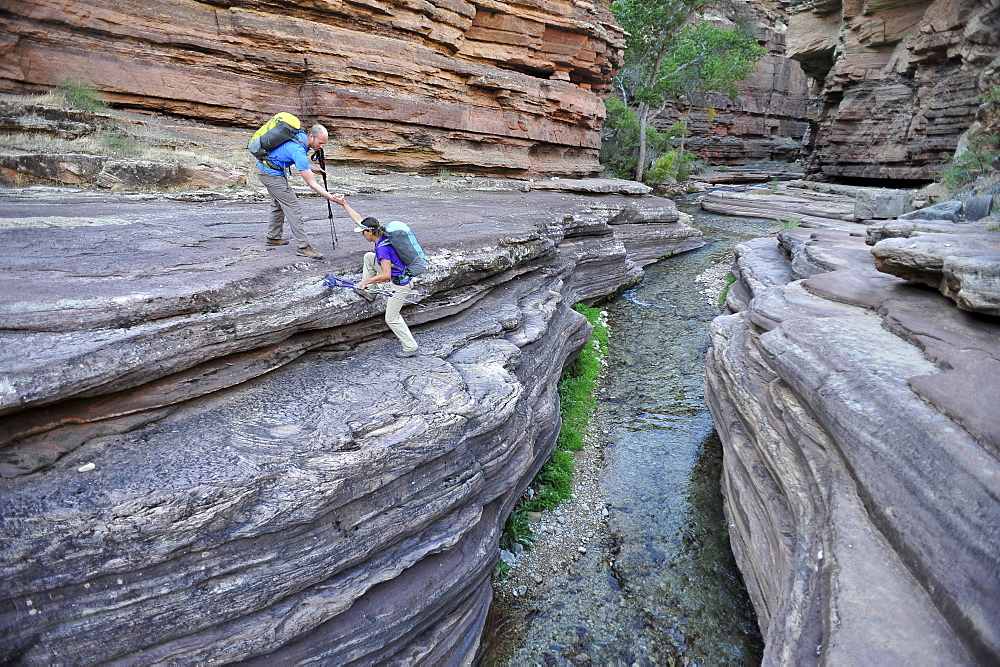 Hikers walk along Deer Creek Narrows in the Grand Canyon outside of Fredonia, Arizona November 2011.  The 21.4-mile loop starts at the Bill Hall trailhead on the North Rim and descends 2000-feet in 2.5-miles through Coconino Sandstone to the level Esplanada then descends further into the lower canyon through a break in the 400-foot-tall Redwall to access Surprise Valley.  Hikers connect Thunder River and Tapeats Creek to a route along the Colorado River and climb out Deer Creek.