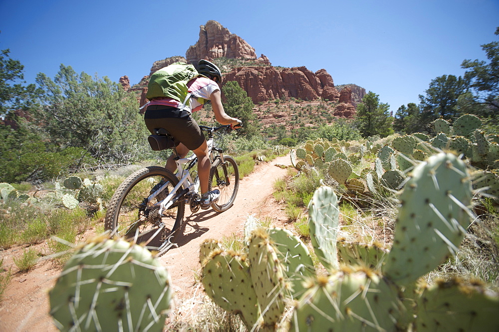 Woman rides the Submarine Rock Loop in South Sedona, Arizona. The trail has everything from slickrock to single track to stairs that lead to Submarine Rock.