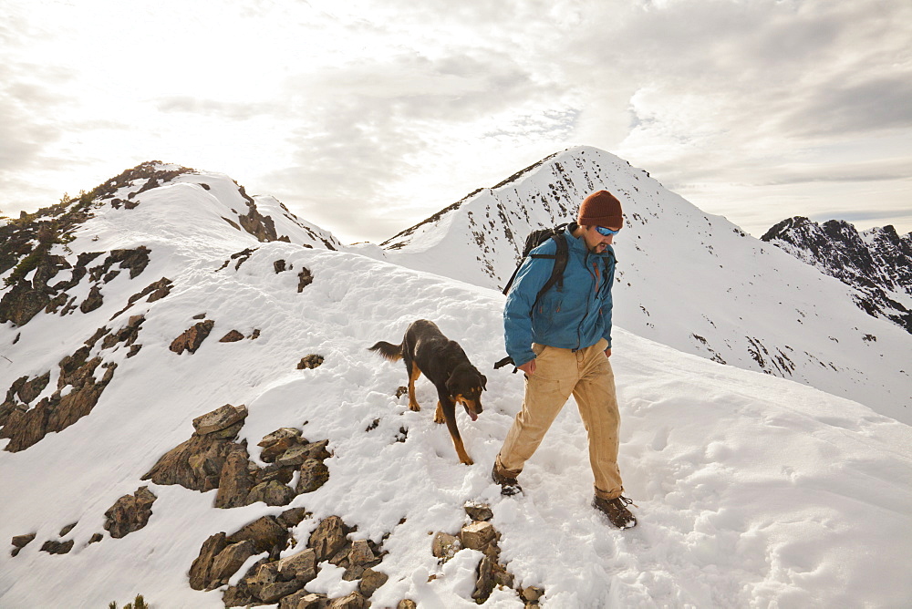 A hiker and his dog descend from  the summit of Frosty Peak in Manning Provincial Park, British Columbia, Canada.