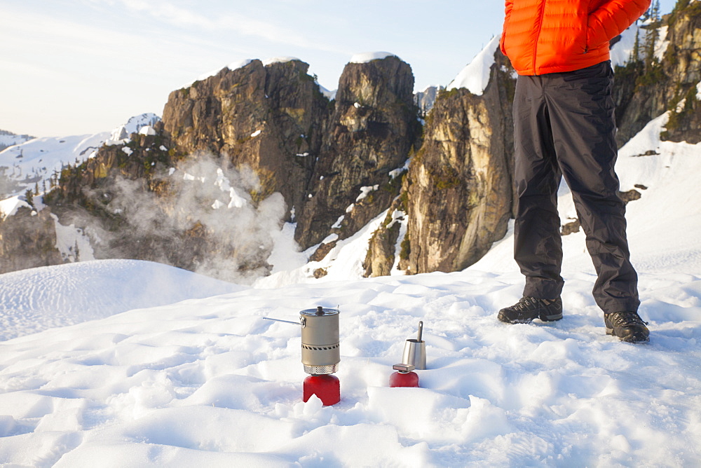 A climber attends to his camping stove while camping in the mountains of British Columbia, Canada.