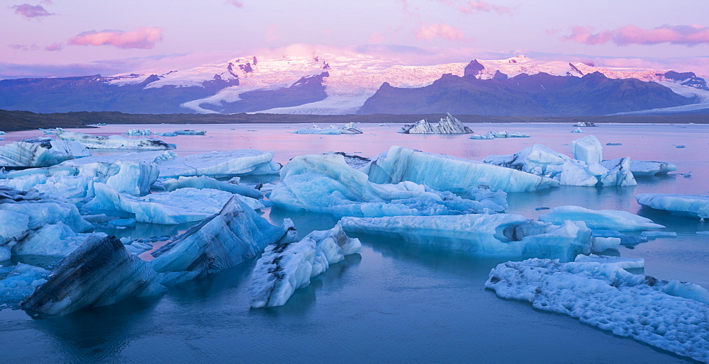 Icebergs near the mouth of Jökulsárlón Glacier Lagoon at sunrise in Southern Iceland.