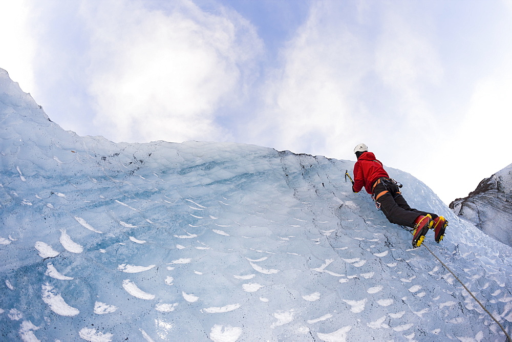 Climber on the icelandic glacier Solheimajokull during winter. South Iceland.