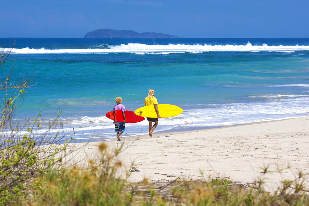 Surfers on a beach.Sumbawa island.Indonesia