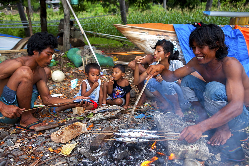 A fisherman?s family eats after cooking the fish they caught in the town of Amed in Bali, Indonesia.