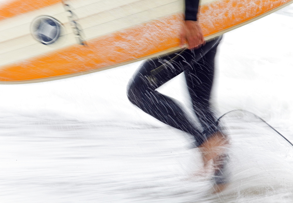 Close up of a Surfer carrying colourful surf board from the beach,Cornwall,UK