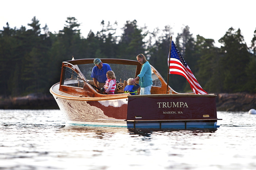 Senior couple show their two grandchildren how to fish, aboard a power yacht in Somes Sound, Maine, United States of America