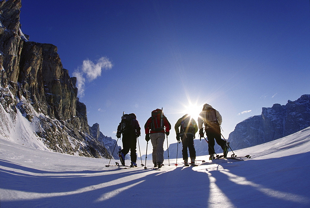 four skiers traversing across frozen fjord near Baffin Island, Canada