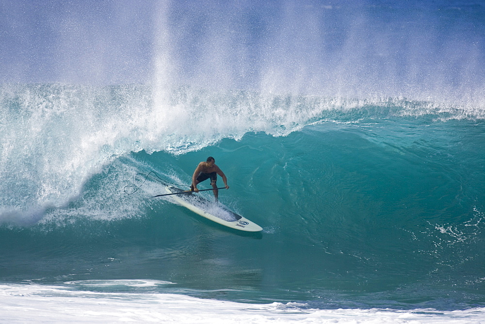 A man stand up paddle surfing, of the north shore of Oahu 02.12.08.