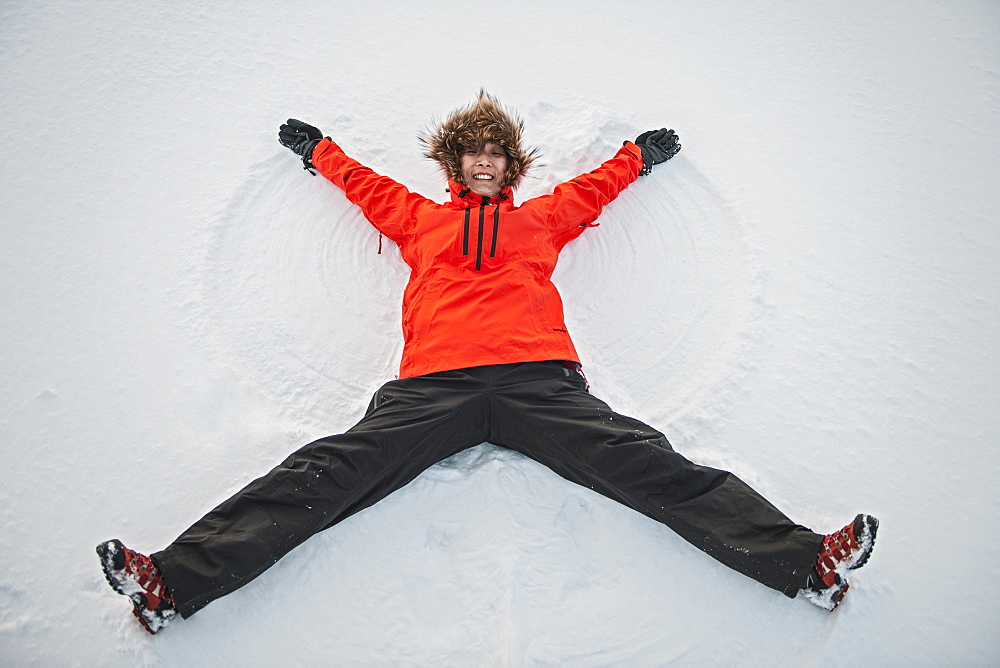 woman making a snow angel in Iceland