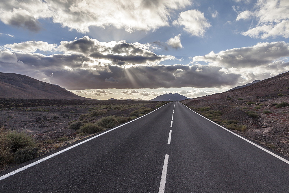 Empty road with mountain and clouds