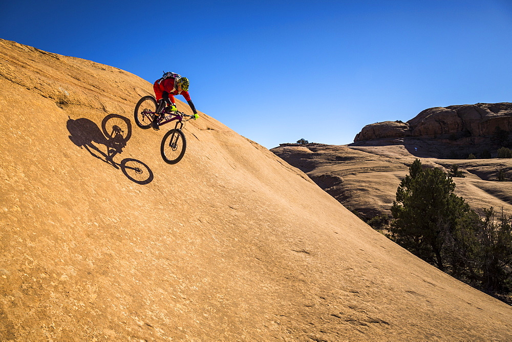 A man mountain biking on the slickrock trail, Moab, Utah.