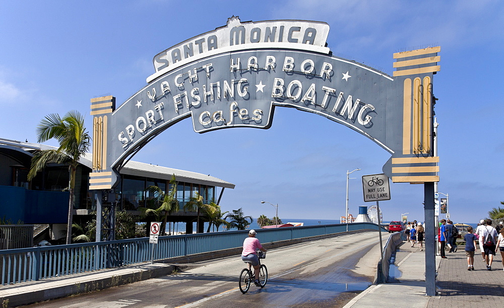 Entrance arch to Santa Monica Pier, from the Pacific Coast Highway. A popular excursion spot for more than a century, the Santa Monica Pier draws crowds daily. From Wikipedia: "The Santa Monica Pier is a large double-jointed pier located at the foot of Colorado Avenue in Santa Monica, California and is a prominent, 100-year-old landmark. The pier contains Pacific Park, a family amusement park with its one-of-a-kind, state-of-the-art, solar paneled Ferris wheel. It also has an original carousel hippodrome from the 1920s, the Santa Monica Pier Aquarium operated by Heal the Bay, shops, entertainers, a video arcade, a trapeze school, pubs, and restaurants. The west end of the pier is a popular location for anglers.