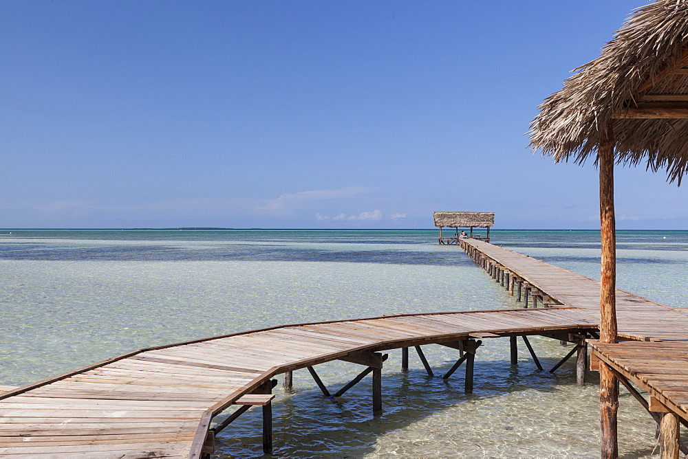 Wooden jetty entering turquoise water with no people in Cayo Guillermo, Cuba