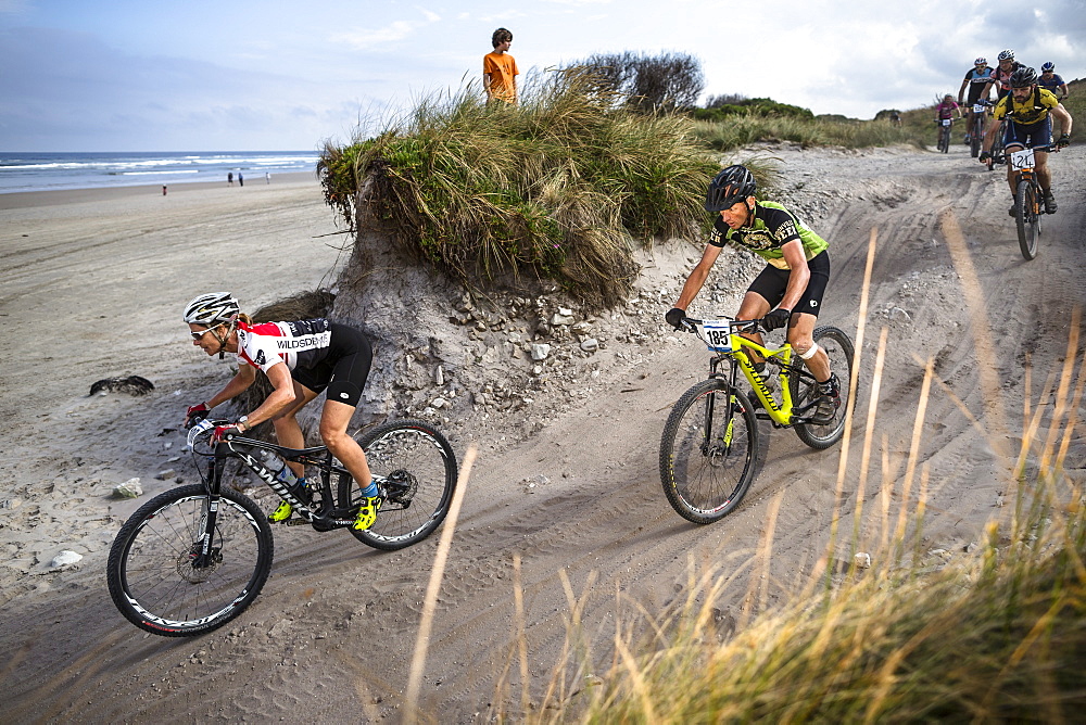 Mountain bikers merge onto Ocean Beach during the last stage of Wildside MTB 2016 in Tasmania.