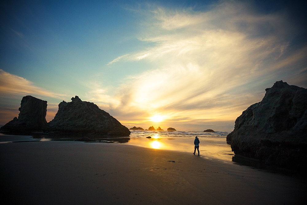 A young woman walks along Bandon Beach, Oregon, United States of America