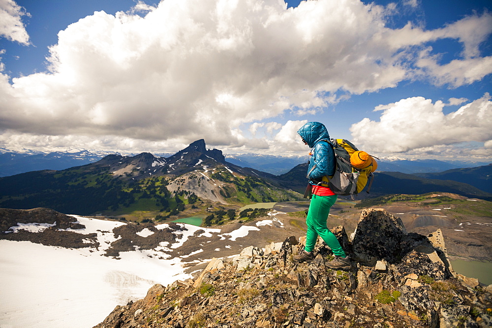 A young woman hiking on Panorama Ridge with Black Tusk Mountain in the background in Garibaldi Provincial Park, British Columbia, Canada.