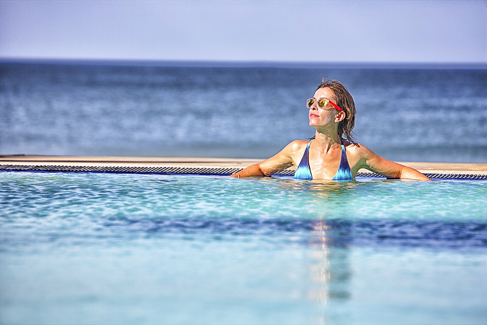 Woman sunbathing by a pool in Nilaveli. Sri Lanka