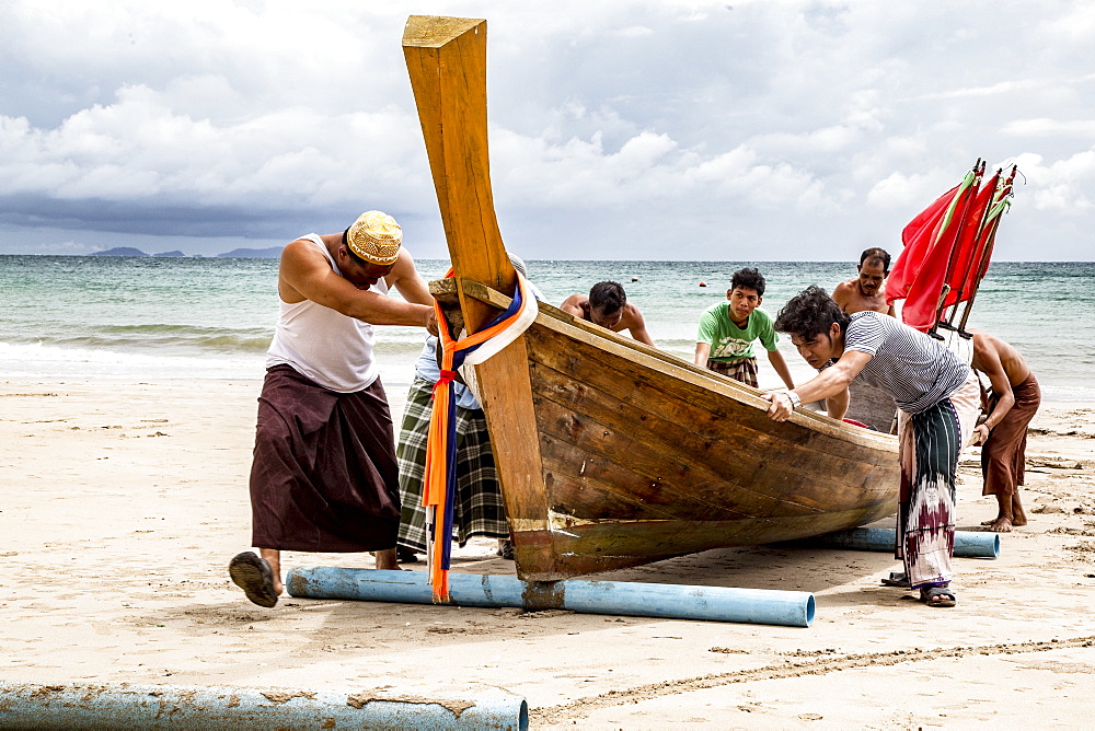 Fishermen on Koh Lanta Island in Thailand push Boat to Shore