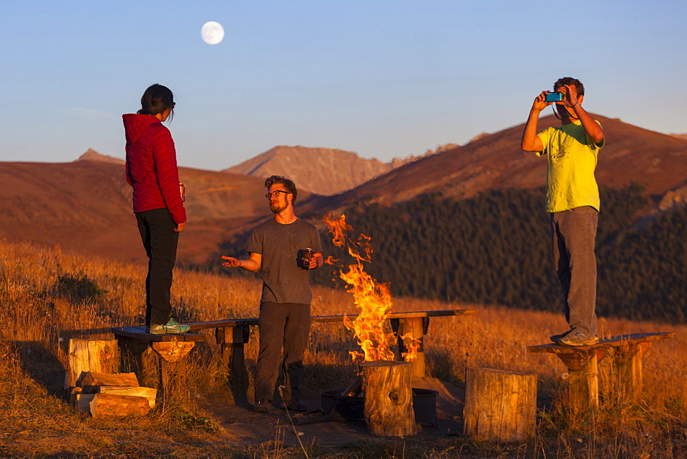 Friends hang out by the campfire outside the Jackal Hut, White River National Forest, Colorado.