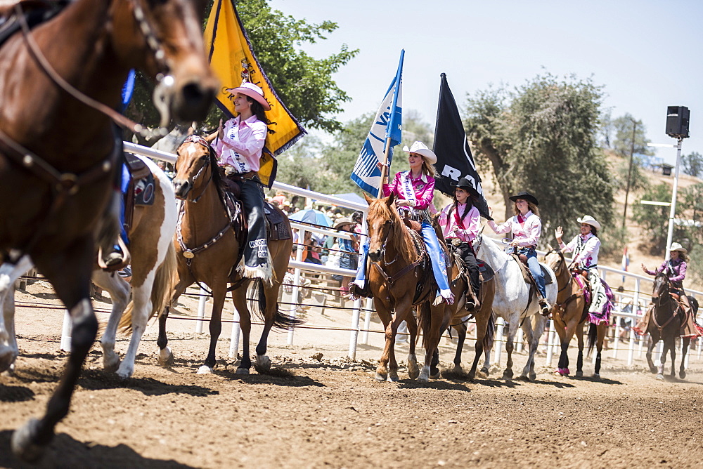 Cowgirls ride their horses during proceedings at the Woodlake Lions Rodeo rodeo in Woodlake, Calif., on May 10, 2015.