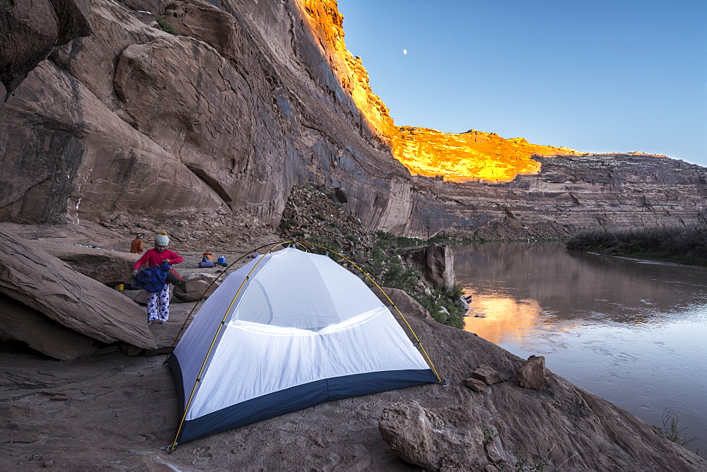 A young girl getting ready for bed in a tent while camping on sandstone along the Labyrinth Canyon section of the Green RIver, Green River, Utah.