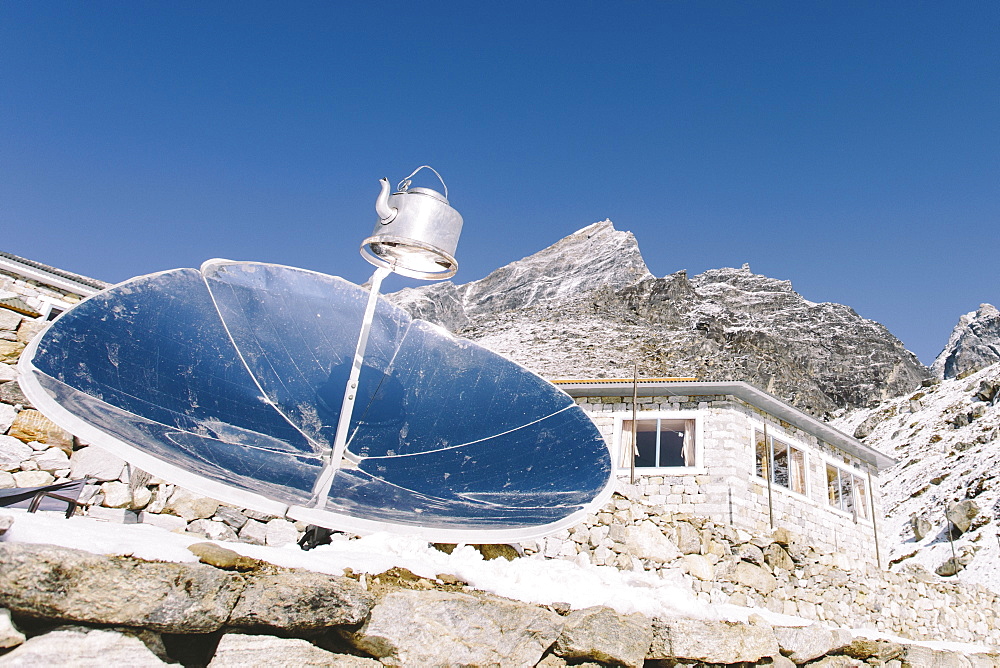 A reflector boils water in a kettle at high altitude in Nepal's Everest Region.