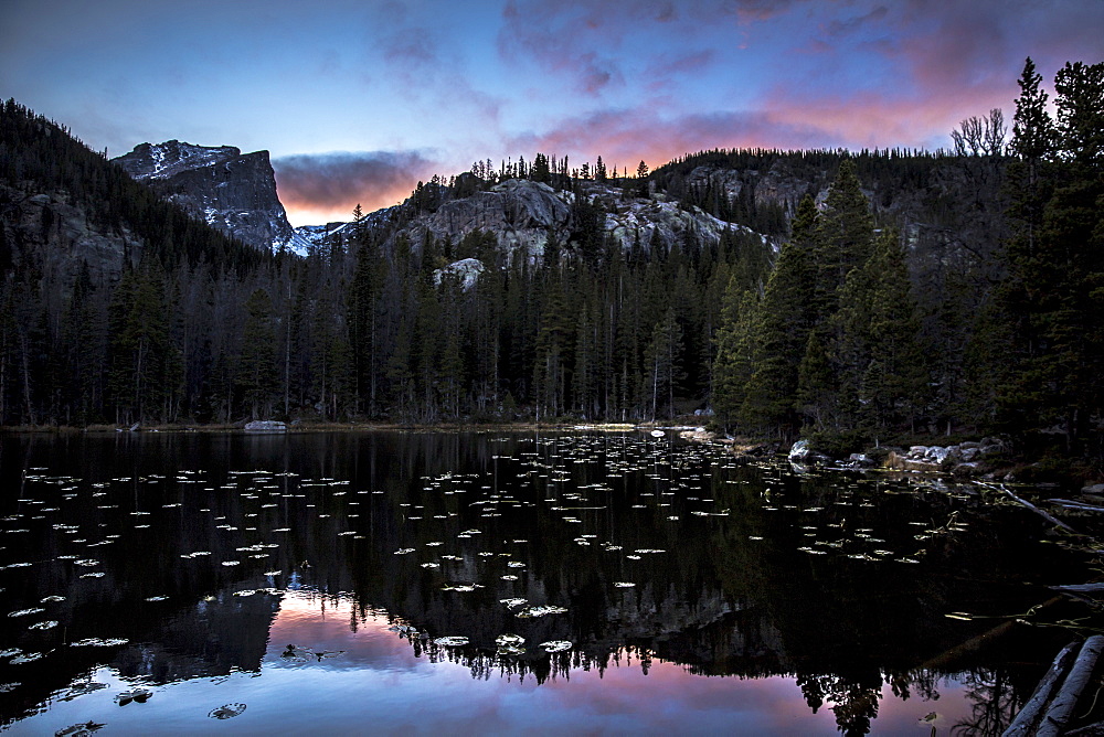 Reflection of the mountains and Hallet Peak on a lake at sunset in Rocky Mountain National Park, Colorado