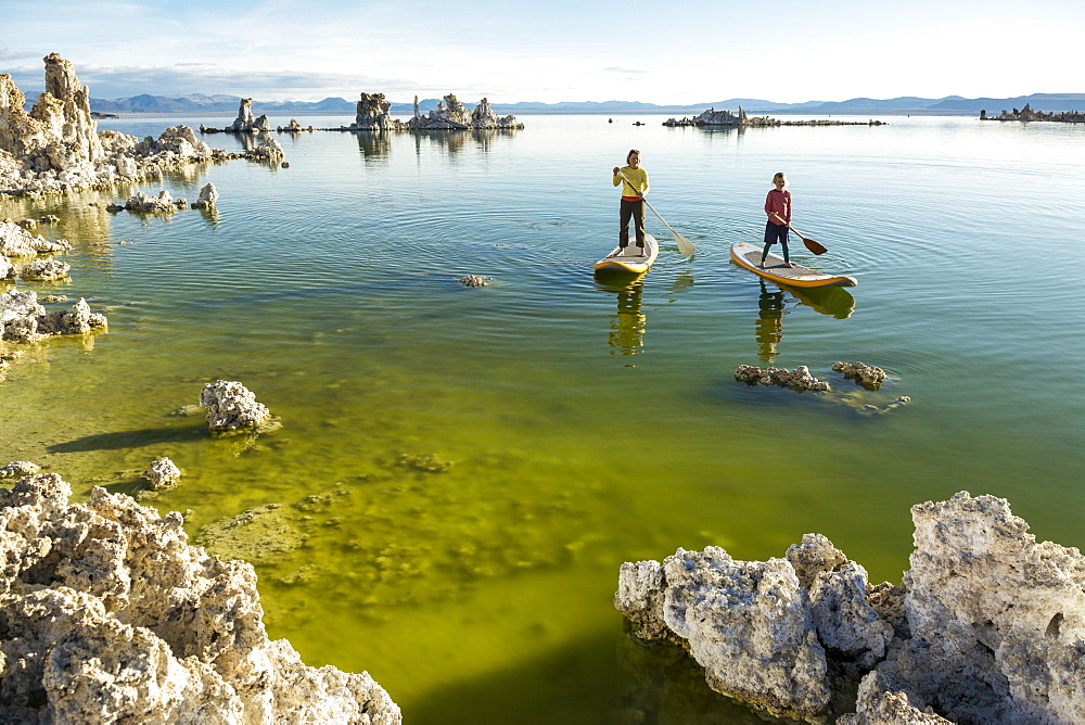 A woman and her daughter stand up paddleboarding on Mono Lake from South Tufa Beach, Lee Vining, California.