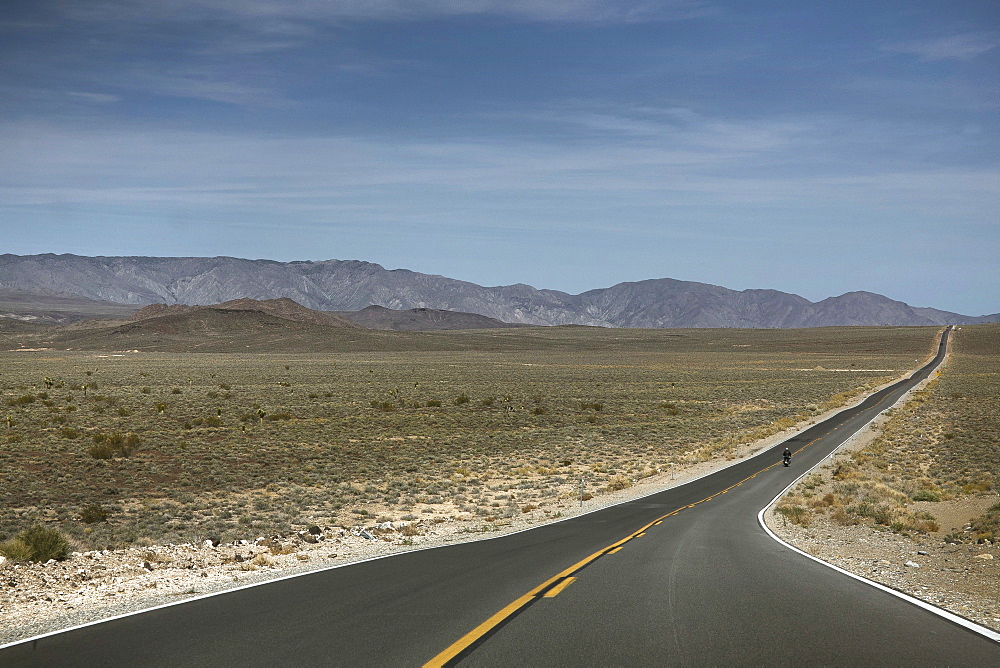 A Person Rides A Motorcycle On A Road Leads To Death Valley Of California