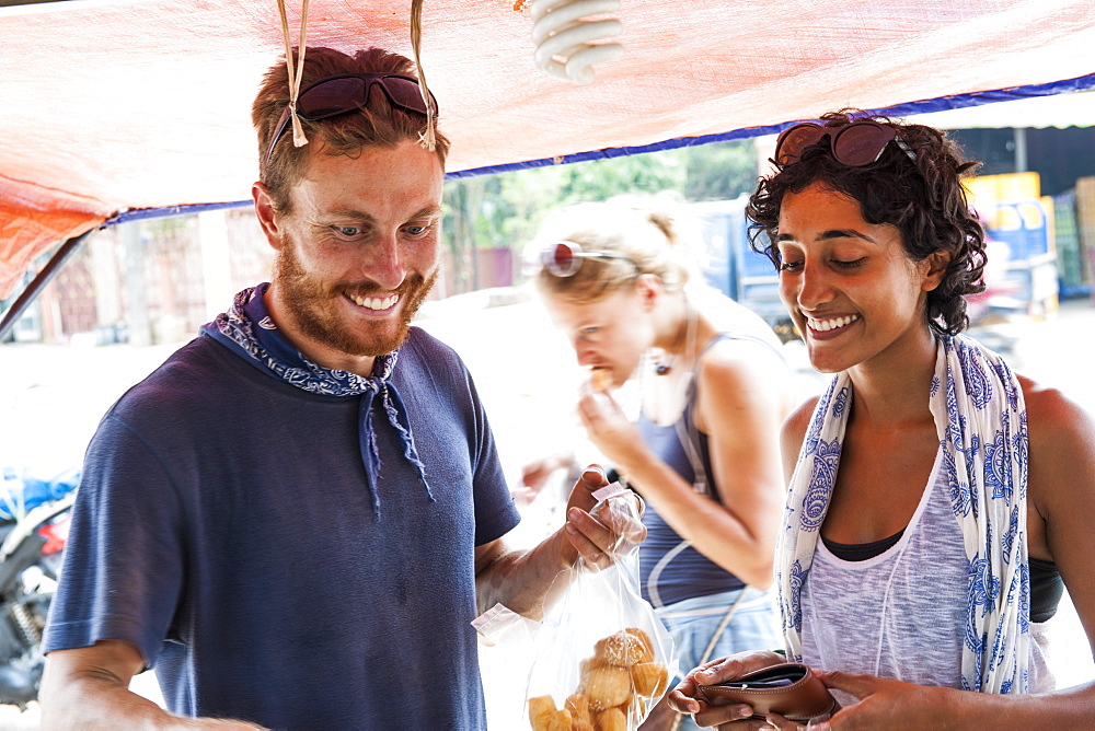 Happy Friends Purchasing Items On A Food Stall