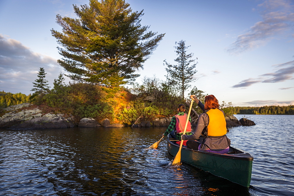 A Young Couple Paddles A Canoe On Long Pond In Maine's North Woods Near Greenville, Maine