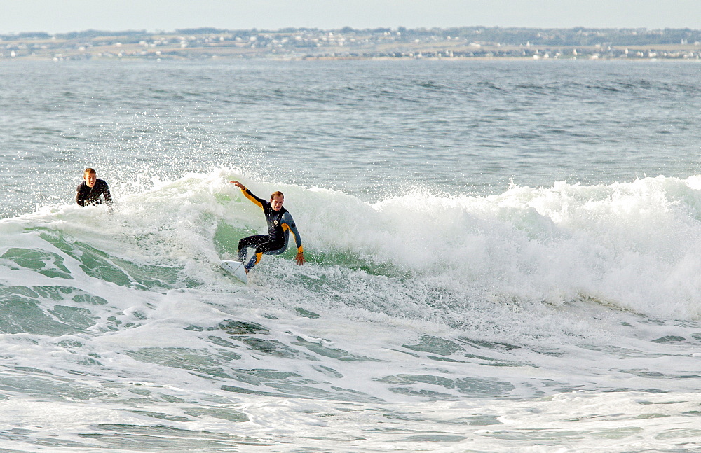 Two Men Surfing On The Oceanic Wave In Pointe De La Torche